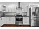 Modern kitchen with white cabinets, stainless steel appliances, and black countertops in a well-lit space at 958 Crew Sw St, Atlanta, GA 30315