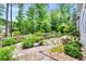 An enclosed backyard featuring a garden, grass, landscaping, and a stone walkway at 11190 Serenbe Ln, Chattahoochee Hills, GA 30268