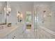 Bright bathroom with dual sinks, marble floors, and a glass shower enclosure at 11190 Serenbe Ln, Chattahoochee Hills, GA 30268