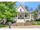 Charming two-story home with a welcoming front porch and manicured landscaping at 11190 Serenbe Ln, Chattahoochee Hills, GA 30268