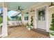 Relaxing front porch with stylish seating, wooden floors, and a view of the neighborhood at 11190 Serenbe Ln, Chattahoochee Hills, GA 30268