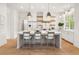Bright kitchen with a central island, stylish bar stools, and open shelving for storage and decor at 11190 Serenbe Ln, Chattahoochee Hills, GA 30268