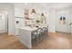 Modern white kitchen with a central island, bar stool seating, and stainless steel appliances at 11190 Serenbe Ln, Chattahoochee Hills, GA 30268
