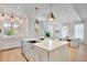 Bright kitchen featuring a large island with seating, stainless steel appliances, and lots of cabinets at 11190 Serenbe Ln, Chattahoochee Hills, GA 30268
