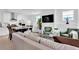 Bright living room with large TV, white walls, and view of the kitchen and dining area at 11190 Serenbe Ln, Chattahoochee Hills, GA 30268