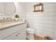 Stylish powder room with a shiplap wall, unique mirror, and modern vanity at 11190 Serenbe Ln, Chattahoochee Hills, GA 30268