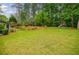 Expansive backyard featuring a lush lawn, mature trees, and a playset at 3389 Robinson Farms Ne Trce, Marietta, GA 30068
