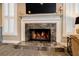 Close up of a well-lit marble fireplace with white mantle and glass doors at 3389 Robinson Farms Ne Trce, Marietta, GA 30068