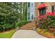 Close-up of the front entrance with brick steps, wrought iron railings, and lush landscaping with vibrant red flowers at 3389 Robinson Farms Ne Trce, Marietta, GA 30068