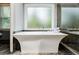 The bright main bathroom features a stand-alone tub and an oversized window to provide natural light at 3389 Robinson Farms Ne Trce, Marietta, GA 30068