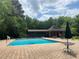 Community pool area with brick pavers, green umbrellas, and picnic tables, ideal for summer relaxation and community gatherings at 3389 Robinson Farms Ne Trce, Marietta, GA 30068