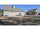 Backyard view with gray home and detached garage, including a patio set on a stone area at 510 Boulder View Parkway, Dallas, GA 30157