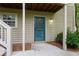 Close-up of the home's entrance featuring a teal storm door, siding, and outdoor lighting at 602 Country Park Se Dr, Smyrna, GA 30080