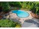 Aerial view of the community pool area, surrounded by trees, lounge chairs, and tables at 602 Country Park Se Dr, Smyrna, GA 30080