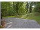 Private backyard with gravel, landscaping, and mature trees create a serene outdoor space at 1080 Westmont Sw Rd, Atlanta, GA 30311
