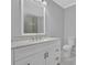 Bathroom featuring a white vanity with marble countertop, large mirror, and a toilet at 1080 Westmont Sw Rd, Atlanta, GA 30311