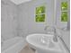 Bathroom with tub, shower, tile surround, window and updated fixtures at 1080 Westmont Sw Rd, Atlanta, GA 30311