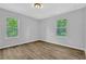 Bright bedroom with wood-look flooring and two windows providing natural light and backyard views at 1080 Westmont Sw Rd, Atlanta, GA 30311