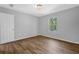 Well-lit bedroom featuring wood-look floors, gray walls, and bright natural light from the window at 1080 Westmont Sw Rd, Atlanta, GA 30311