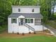 Beautifully landscaped two-story home featuring white siding, black railings, and a lush green lawn at 1080 Westmont Sw Rd, Atlanta, GA 30311