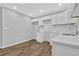 Well-lit kitchen featuring white cabinets, counters and backsplash, plus wood-look floors at 1080 Westmont Sw Rd, Atlanta, GA 30311