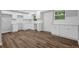 Modern kitchen with white cabinets, wood-look floors, bright lighting, and white countertops at 1080 Westmont Sw Rd, Atlanta, GA 30311