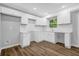 Bright kitchen featuring white cabinets, a white backsplash, white counters, and wood-look floors at 1080 Westmont Sw Rd, Atlanta, GA 30311