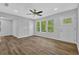 Open living room with stylish ceiling fan, wood-look floors, and multiple windows at 1080 Westmont Sw Rd, Atlanta, GA 30311
