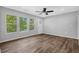 Bright living room showcasing wood-look flooring, a ceiling fan, and an abundance of windows with natural light at 1080 Westmont Sw Rd, Atlanta, GA 30311