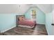 Cozy bedroom featuring a slanted ceiling, wood-look flooring, and a window with natural light at 4835 Liberty Rd, Villa Rica, GA 30180