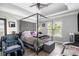Spacious bedroom featuring tray ceilings, a four-poster bed, and a dark wood floor at 4835 Liberty Rd, Villa Rica, GA 30180