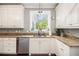 Well-lit kitchen features granite countertops and stainless steel dishwasher beneath white cabinetry and a mounted, decorative light at 4835 Liberty Rd, Villa Rica, GA 30180