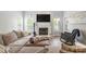 Bright living room featuring a fireplace, hardwood floors, natural lighting, and comfortable gray upholstered furniture at 4835 Liberty Rd, Villa Rica, GA 30180