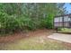 Spacious backyard with a concrete patio, deck, mature trees and a lush green landscape at 5975 Tate Dr, Austell, GA 30106