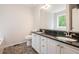 A bathroom features double sinks, a black countertop, and wood-look flooring offering a clean and functional space at 5975 Tate Dr, Austell, GA 30106