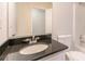 A bathroom features a black countertop, sink, and a tub/shower offering essential amenities in a compact space at 5975 Tate Dr, Austell, GA 30106