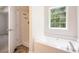 A bright bathroom features a tub, separate shower, and a window providing natural light and a serene space at 5975 Tate Dr, Austell, GA 30106