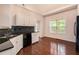 Kitchen featuring hardwood floors, white cabinets, black appliances, and a view to the backyard at 5975 Tate Dr, Austell, GA 30106