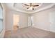 A spacious main bedroom features neutral carpet, tray ceiling, ceiling fan, and access to a bathroom at 5975 Tate Dr, Austell, GA 30106