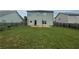 Backyard view with green grass, wooden fence, and the back of the home with a patio at 2166 Villa Spring Ct, Dacula, GA 30019