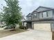 The home's facade boasts a two-car garage, coordinating shutters, manicured landscaping, and a neatly kept lawn at 2166 Villa Spring Ct, Dacula, GA 30019