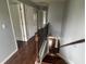 Hallway featuring hardwood floors, staircase with dark wood and metal banister and neutral paint at 2166 Villa Spring Ct, Dacula, GA 30019