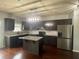 Modern kitchen features dark cabinets, granite countertops, stainless steel appliances, and an island with pendant lighting at 2166 Villa Spring Ct, Dacula, GA 30019