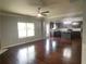 Spacious living area featuring hardwood floors, neutral walls, a ceiling fan, and seamless integration with the kitchen at 2166 Villa Spring Ct, Dacula, GA 30019