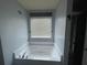 Bathroom with tub, tile surround and window providing natural light at 2166 Villa Spring Ct, Dacula, GA 30019