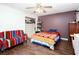 This bedroom has a large closet, dark wood floors, a colorful couch, and a ceiling fan at 4812 Pamela Nw Ct, Acworth, GA 30101