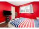 Bedroom showcasing hardwood floors, red walls, and an exterior view window at 4812 Pamela Nw Ct, Acworth, GA 30101