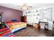 Bright bedroom featuring dark wood floors, ceiling fan, and open shelving at 4812 Pamela Nw Ct, Acworth, GA 30101