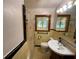 Clean, vintage bathroom with shower, vanity and decoratively framed windows at 5760 Brenda Sw Dr, Mableton, GA 30126