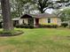 Charming yellow home with landscaped front yard, lovely shrubbery and manicured lawn at 5760 Brenda Sw Dr, Mableton, GA 30126